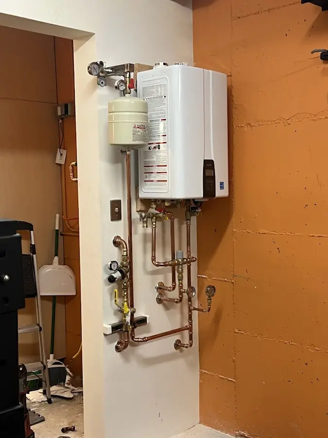 Plumbing technician inspecting water heater connections in Pennsburg